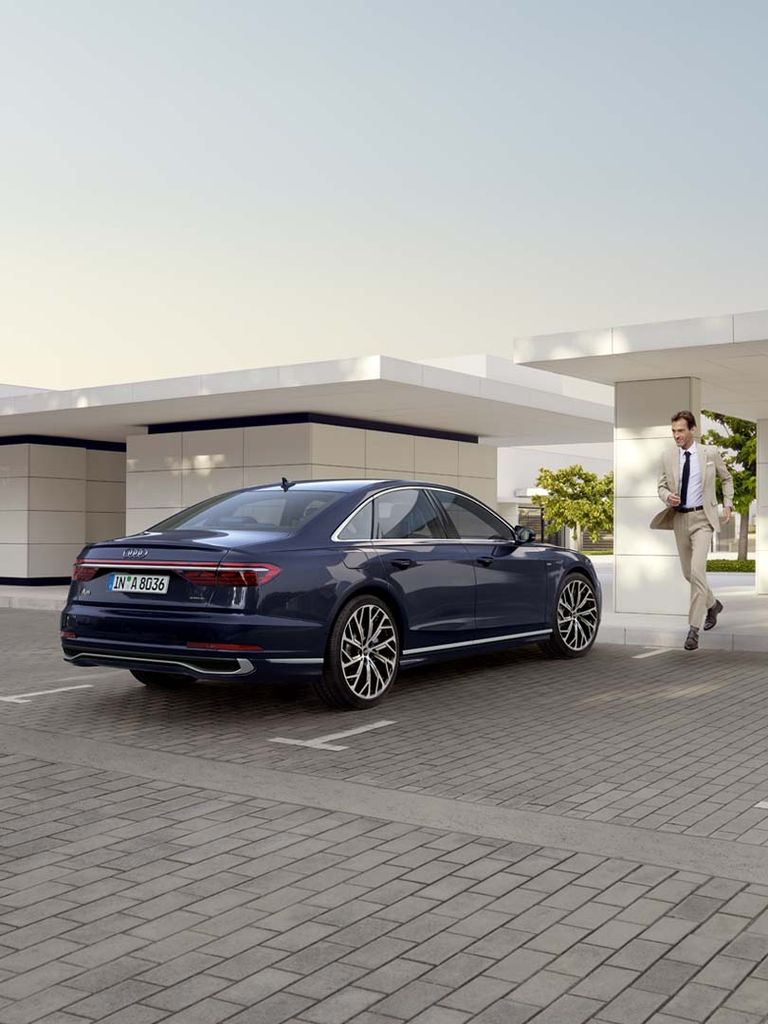 Side rear view of the A8 in blue with a man on the side