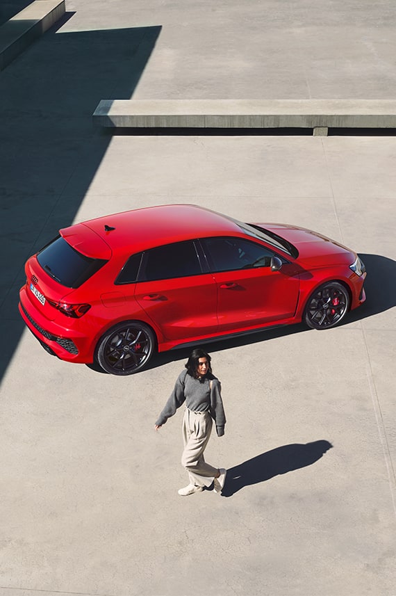 Audi RS 3 Sportback sideways from above and a young woman